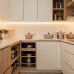 Cuisine moderne fonctionnelle avec plan de travail dégagé, rangements organisés et lumière douce, ambiance élégante et pratique.
