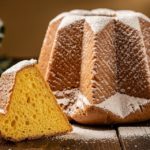 Pandoro traditionnel en forme d'étoile à huit branches saupoudré de sucre glace sur une table en bois rustique