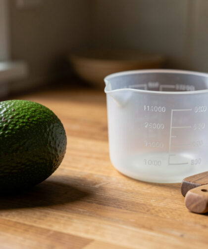 Avocat posé à côté d’objets de cuisine servant à estimer son poids sans balance.